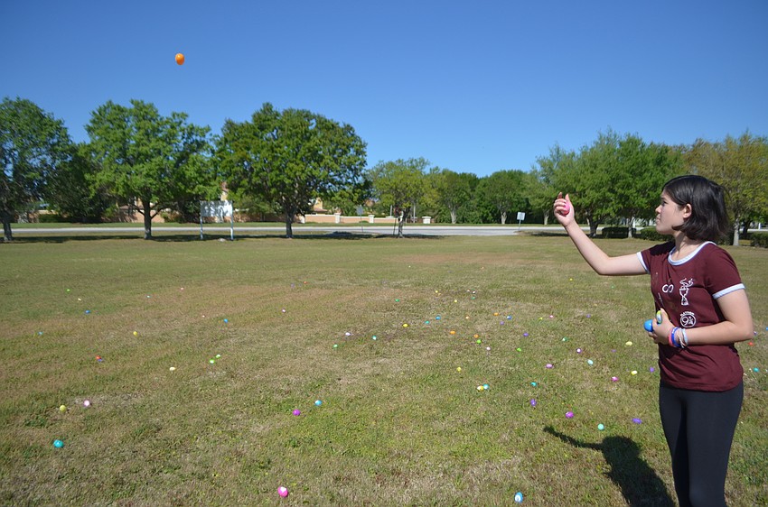 Regan Baker, 13, from Lakewood Ranch, tosses out the eggs before the Harvest Easter egg hunt.
