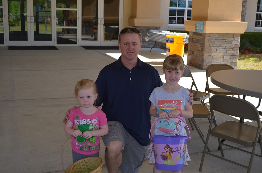 Sarasota's 2-year-old Meghan Cronin with Scott Cronin and Colleen Cronin, 5, bring their baskets out for the egg hunt. She was a little nervous about her first egg hunt.