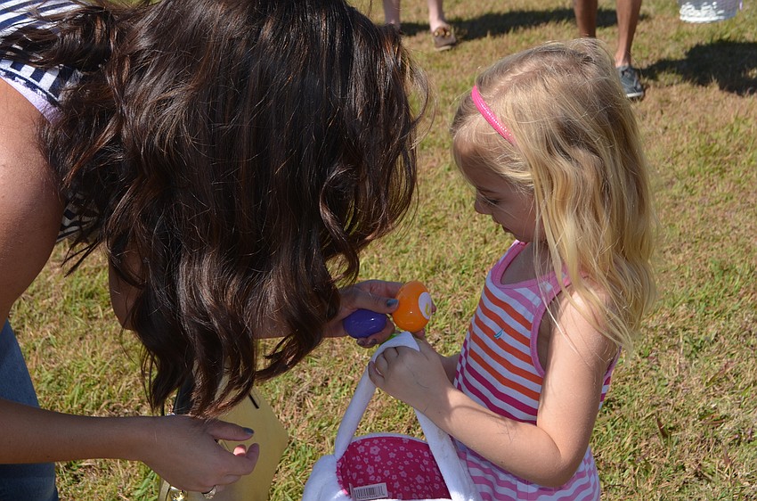 Kinley Solton, 4, from Country Club at Lakewood Ranch, shows her mom, Brittany, the egg she picked up during the hunt.