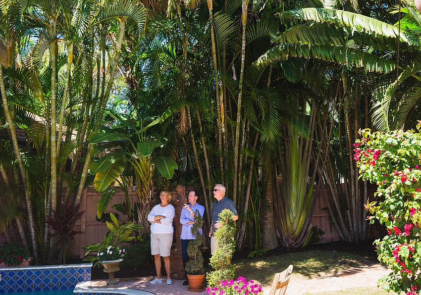 Melissa Littlewood, Jay Price and Andy Knisley explore a Hibiscus Street garden.