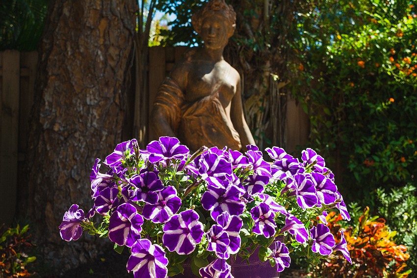 A statue and flowers greet visitors of Cindy Slaalien's garden.