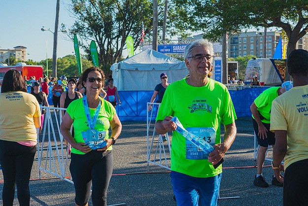 Marcia and Luis Noguirra receive medals after reaching the finish line.