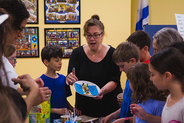 Beth Steiner discusses with students the symbolism behind their craft projects.