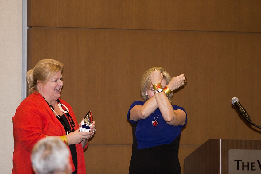 Honoree Teri Hansen shows off her bracelets before addressing the crowd.