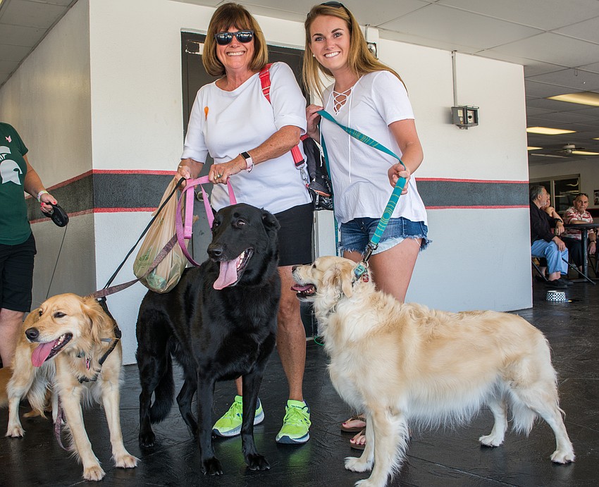 Maggie Moffett and Alex Finnicum with their dogs Moose Riley, a Belgian shepherd who has won in his weight category for the past two years, Ellie and Harper.