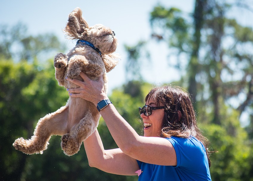 Helen Duvin lifts her dog Dakota in excitement over her win.