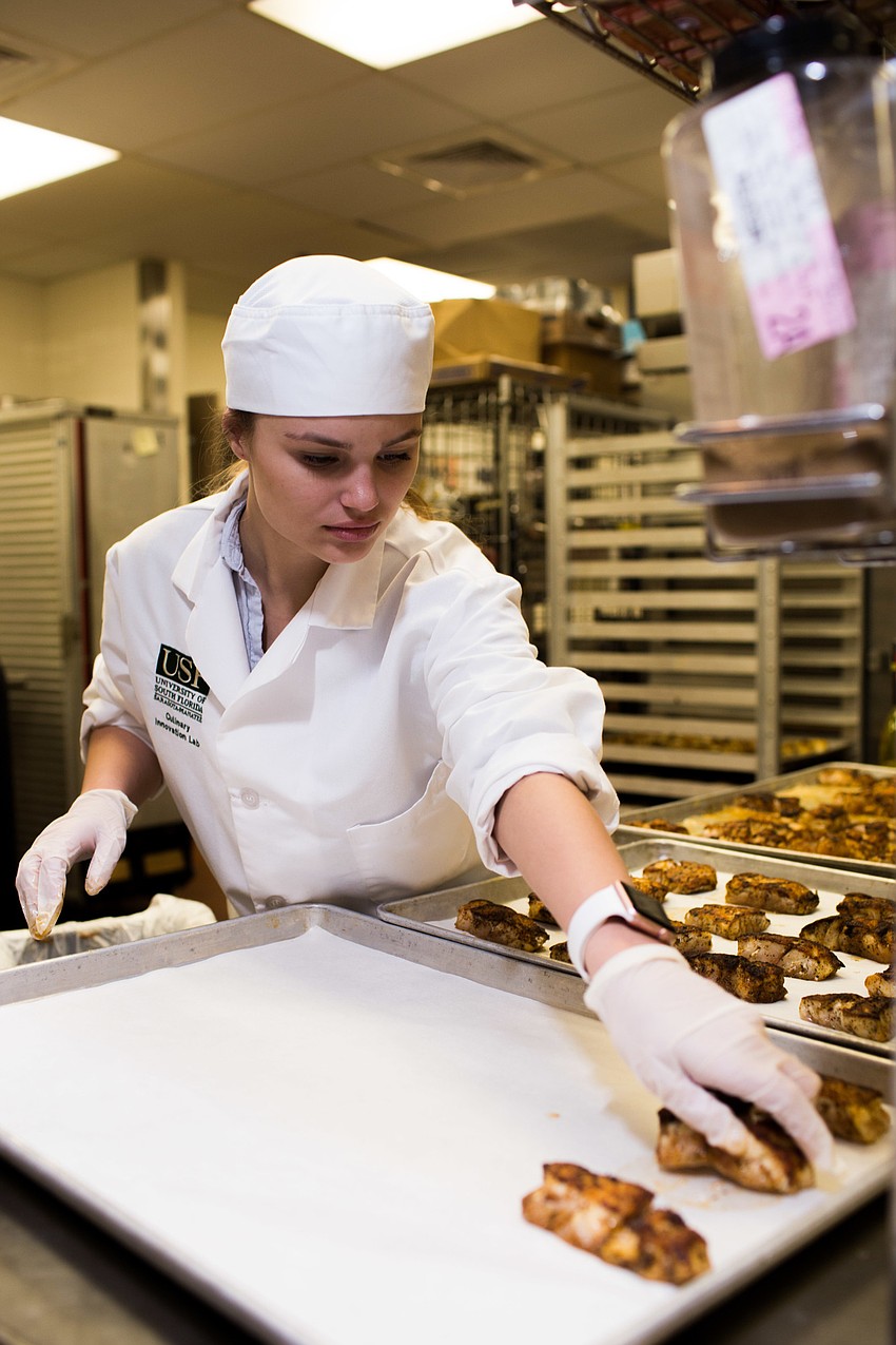 USF student Rachael Davis prepares the entree during cocktail hour.
