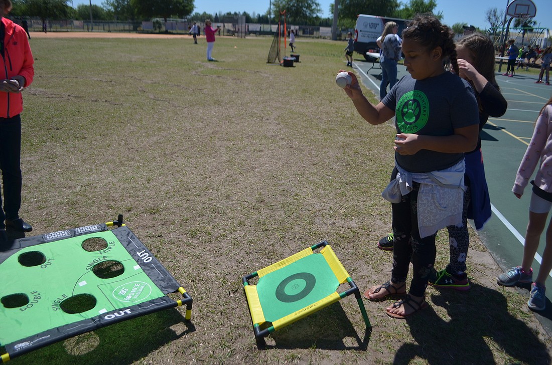 Giada Herra, a third-grader, gears up to drop her ball on the target. She&#39;s shooting to get the ball into the hole.
