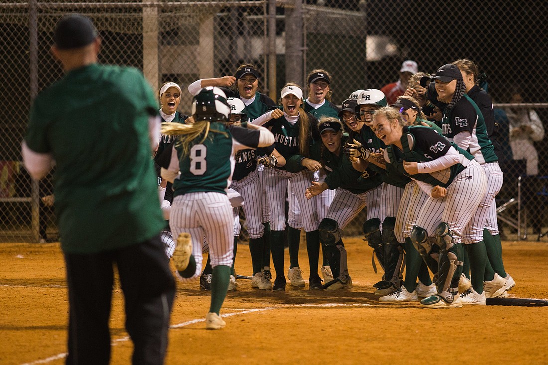 Senior Kailey Christian is greeted at the plate by her Mustangs teammates following her home run against Sarasota High. Photo by Kayleigh Omang.