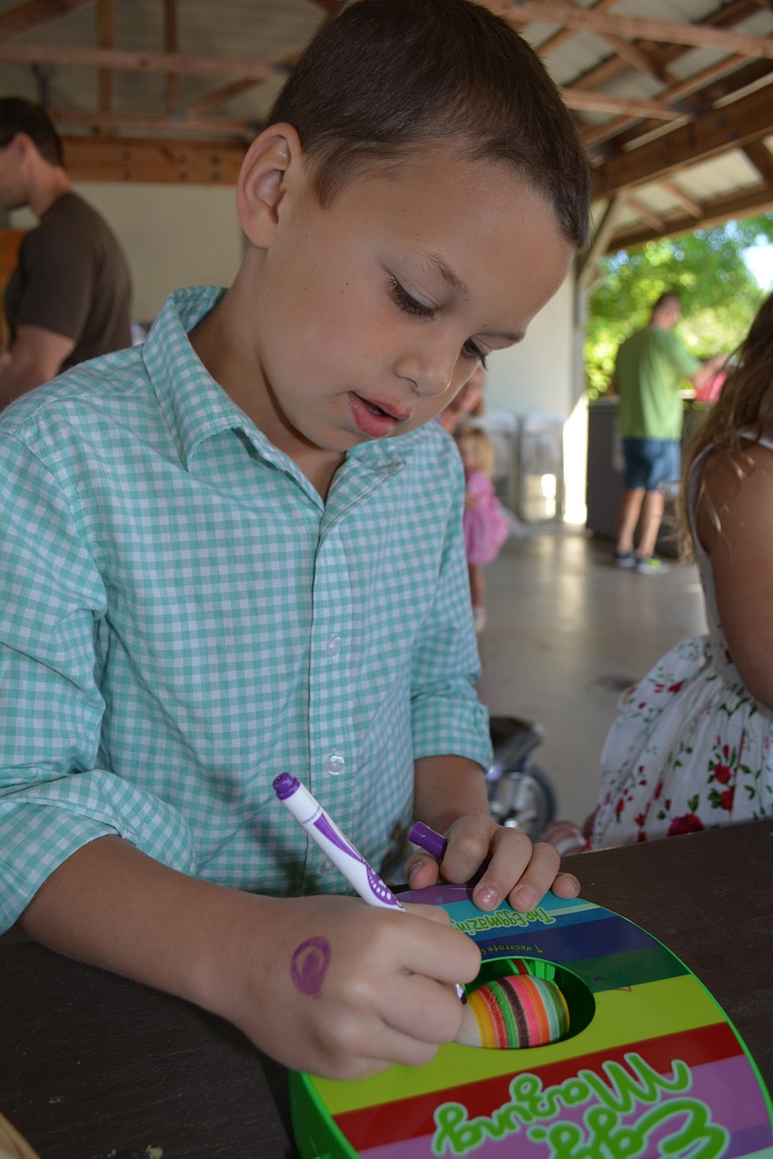 Eight-year-old Matthew Vajanyi, of Central Park, colors a wooden egg while it spins. The craft was presented by the Lakewood Ranch club, SUGAR.
