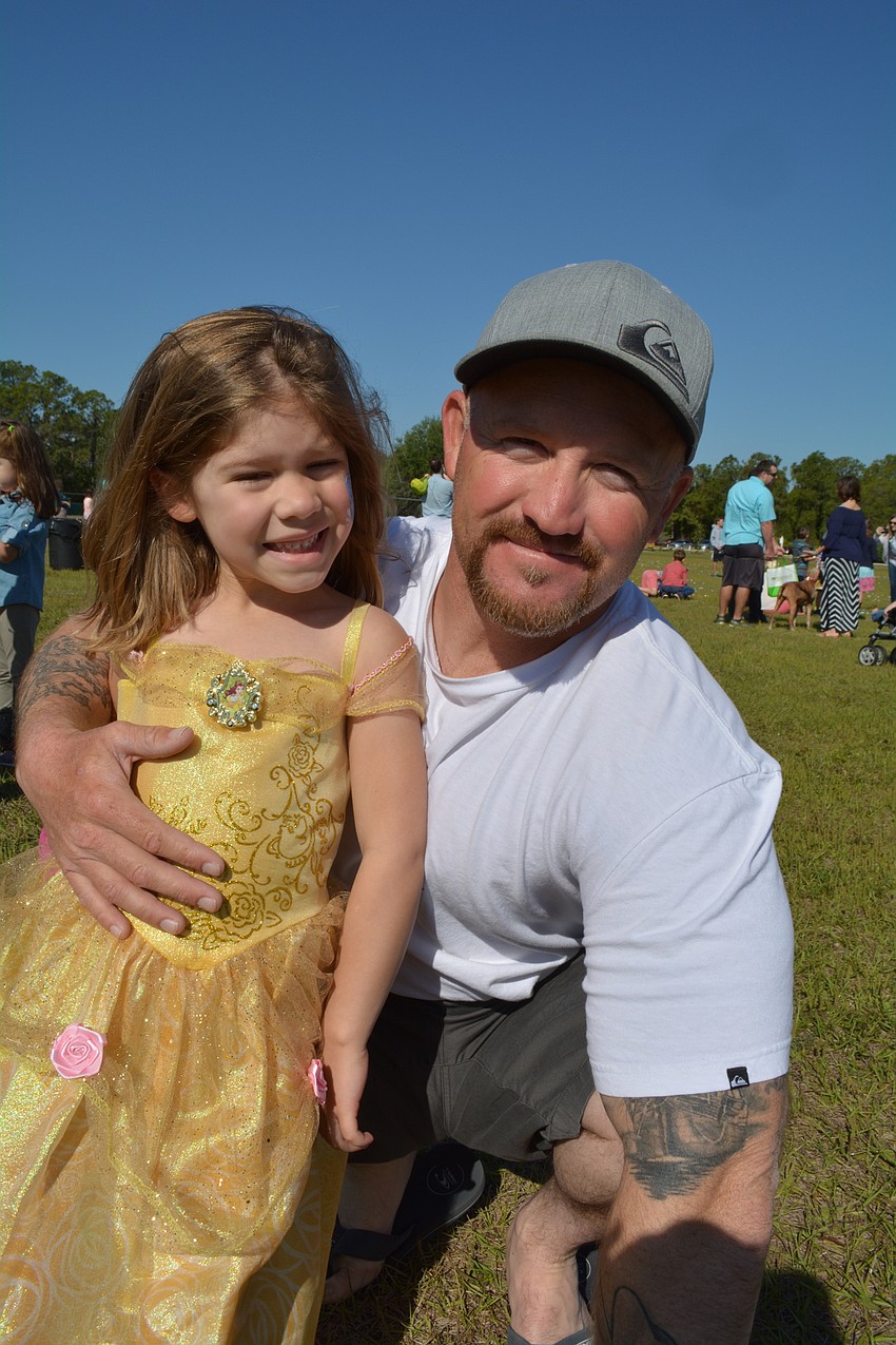 Four-year-old Madison Straw, with her dad, Joe, wears one of her princess dresses for the occasion.