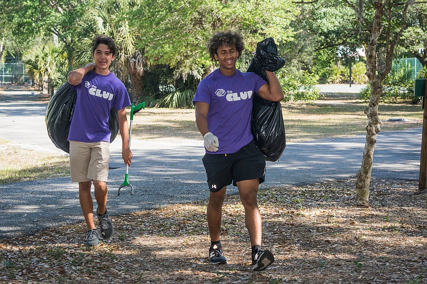 Boys and Girls Club member Alex and Angelo do clean-up work at Potter Park.