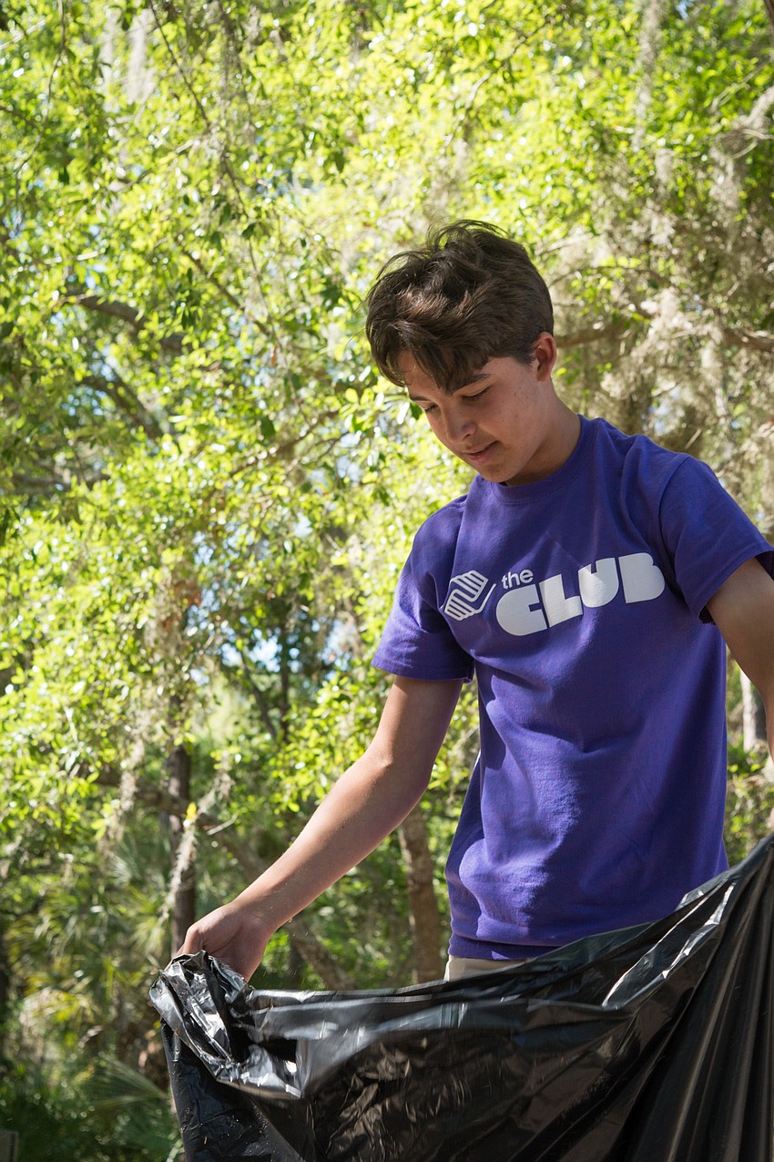 Boys and Girls Club member Alex volunteers his time during spring break to tidy up Potter Park.