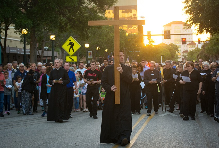 Rev. Chris Wood carries the cross.