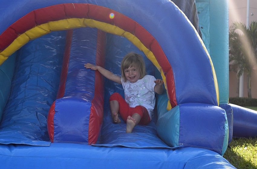 Caroline Whitson is all smiles as she slides down the bounce house.
