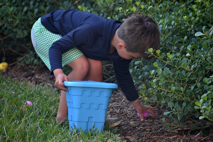 Connor Whitson fills his bucket with Easter eggs.