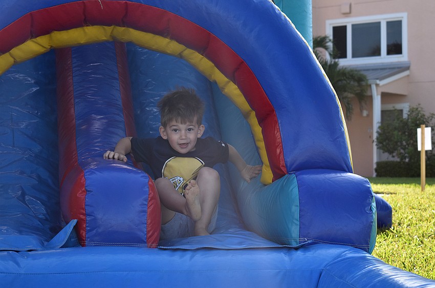 Colin Laciak slides down the bounce house before the egg hunt.