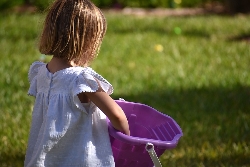 Caroline Whitson fills her bucket with Easter eggs.