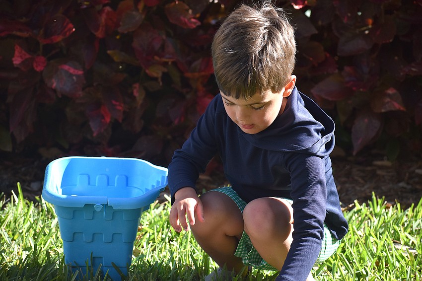 Connor Whitson fills his bucket with Easter eggs.
