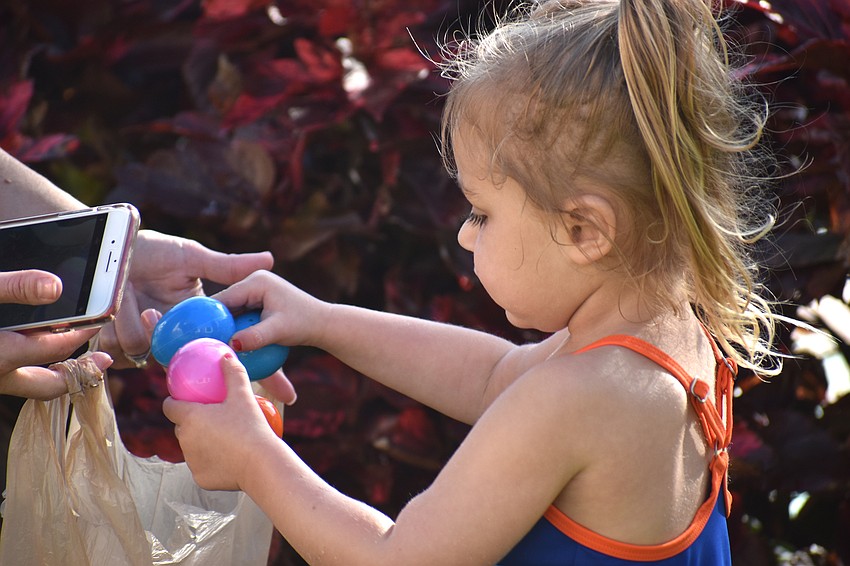 Abby Honroth fills her bag with Easter eggs.