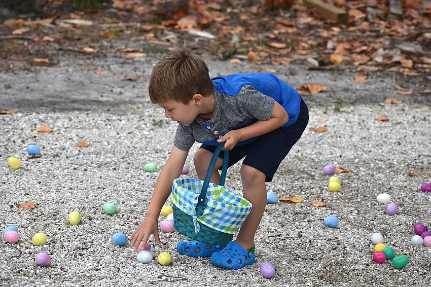 Gavin Zinck fills his basket with Easter eggs.