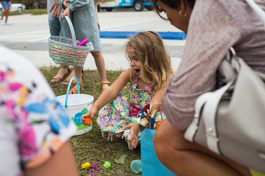 Charlotte Carro sits with her parents as they open the eggs.