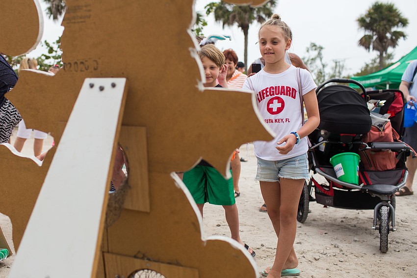 Avery Guyton throws a bean bag into the cutout for a prize.