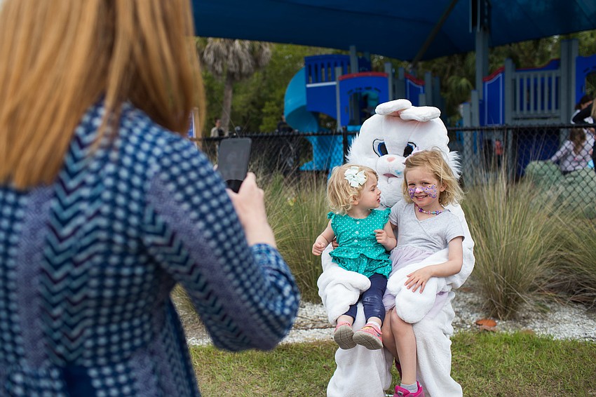 Ashley and Juliet Booth sit on the Easter bunny's lap while their mom takes a photo.