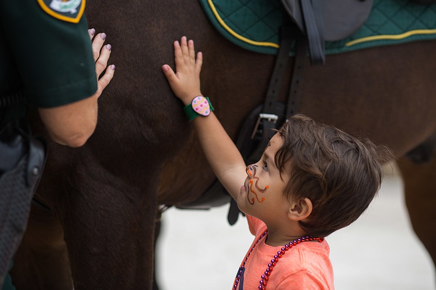 Lorenzo Gonzalez pets the country sheriff horse, Valor.