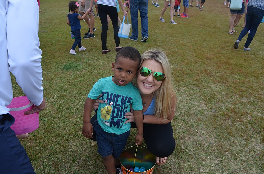 Julius Aaron, 2, and Emily White from Anna Maria Island pause in collecting eggs for a picture.
