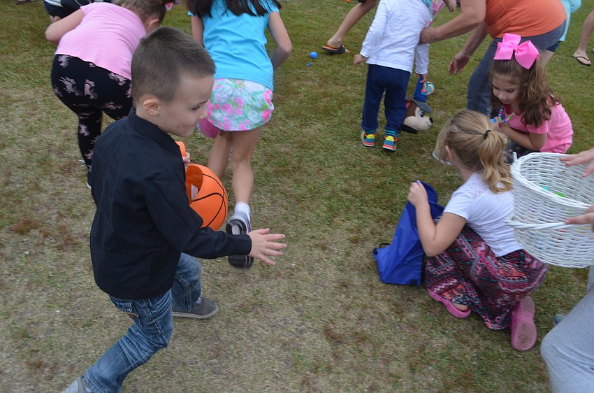 Lakewood Ranch's Logan Lawson, 4, hunts for eggs as children swarm to find more.