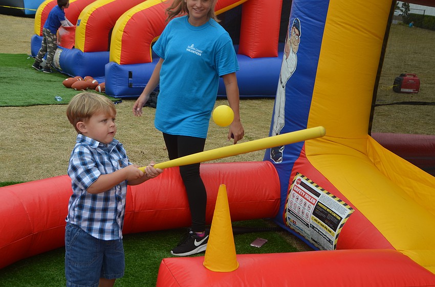 Venice's Auston Sams, 2, takes a swing at a ball at a bouncy house.