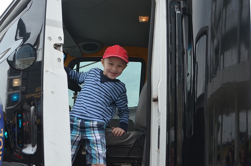 Sarasota's Logan Sell, 5, climbs down from a police truck.