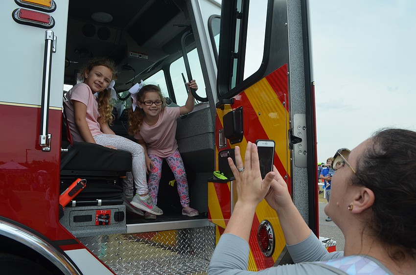 Bradenton's Eleanor and Abigail Rodriguez pose in the fire truck for their mom, Madeline to get a quick picture.