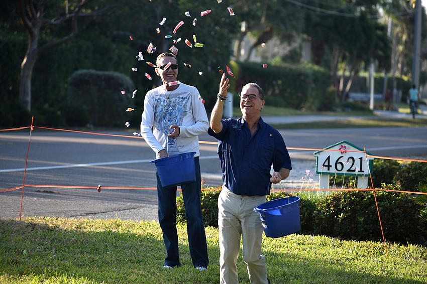 Scott Franza and Jim Helmich scatter candy around Casa Del Mar’s lawn.