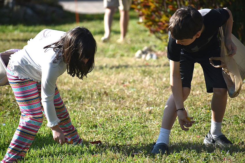 Maggie and Mikey Fitzpatrick search for candy on the lawn.