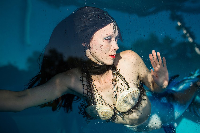 The mermaid swam in the tank throughout cocktail hour.