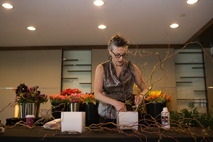 Bella Meyer arranges florals at the front of the room.
