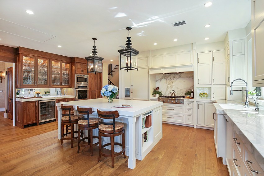 The kitchen features custom cabinets and Calcutta gold marble and quartz.