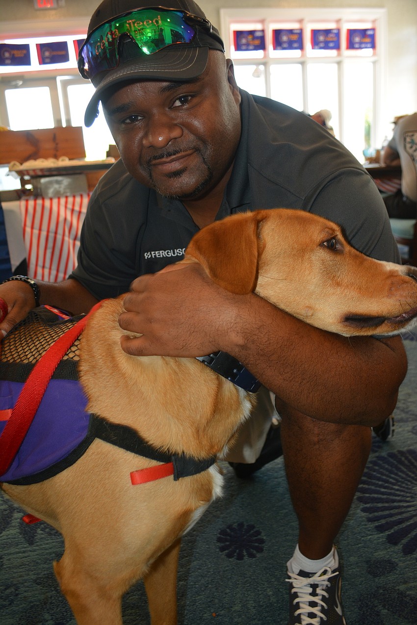Army Staff Sgt. Christopher Gordon hugs his service dog, Blaze, before the tourney.