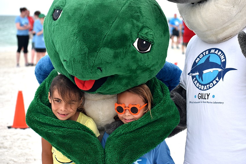 Catalina and Riley Jimenez pose with Shelley the Sea Turtle.