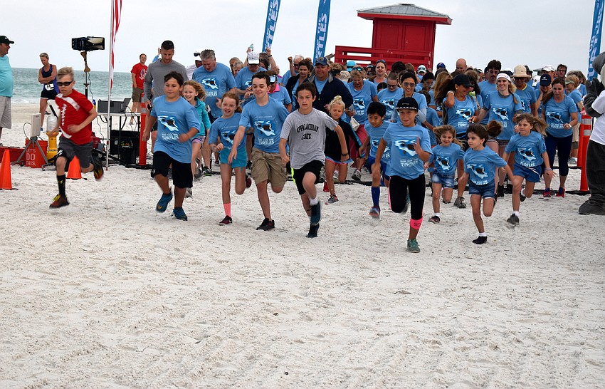 Participants in the 1-mile fun-run/walk take off from the starting line.