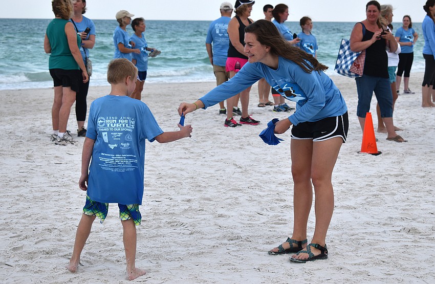 Mote Marketing Manager Sofie Wachtmeister hands out ribbons to the 1-mile fun-run/walk participants as they reach the finish line.