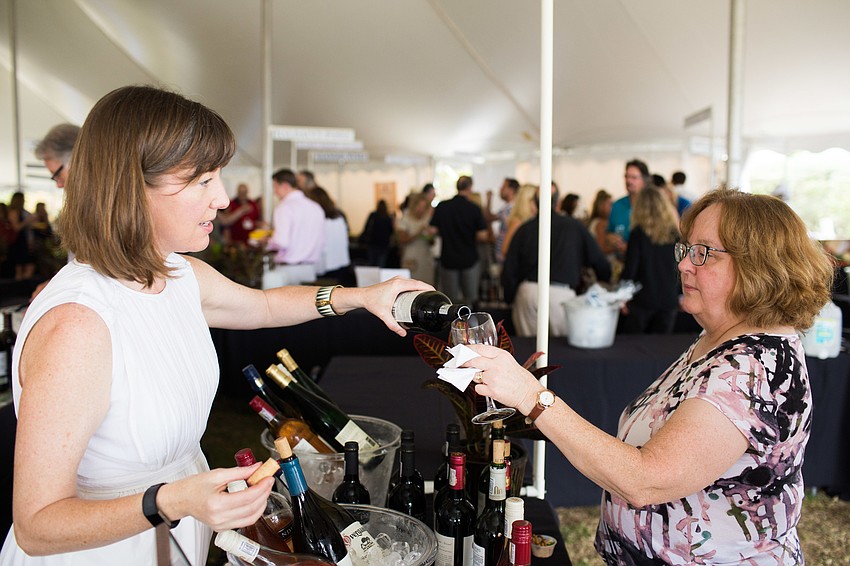 Maura McCarthy pours a glass of wine to a guest.