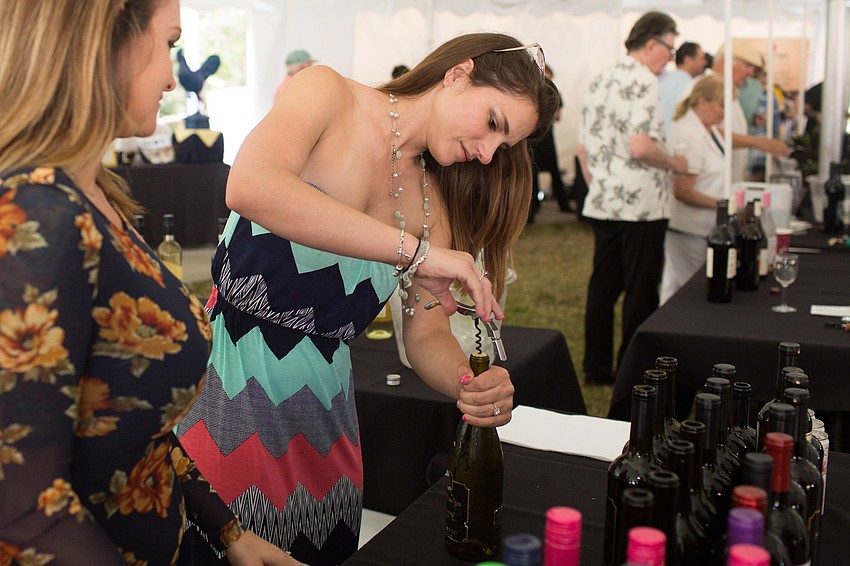 Kristine Steffano opens a bottle of wine.