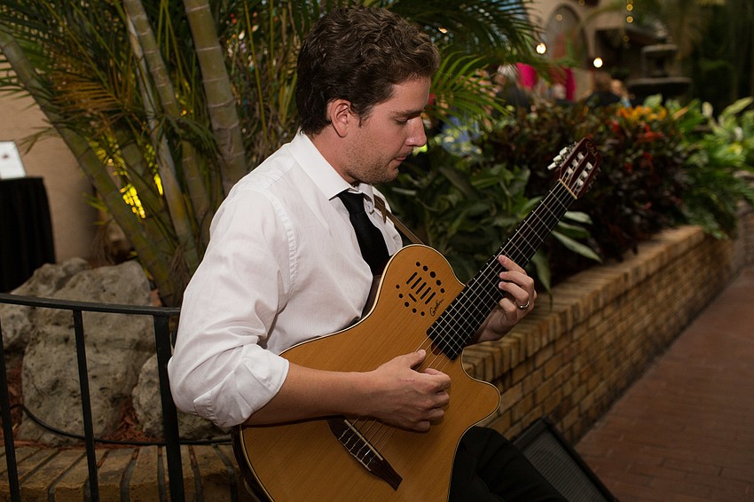 Will Scecina plays guitar for guests as they arrive.