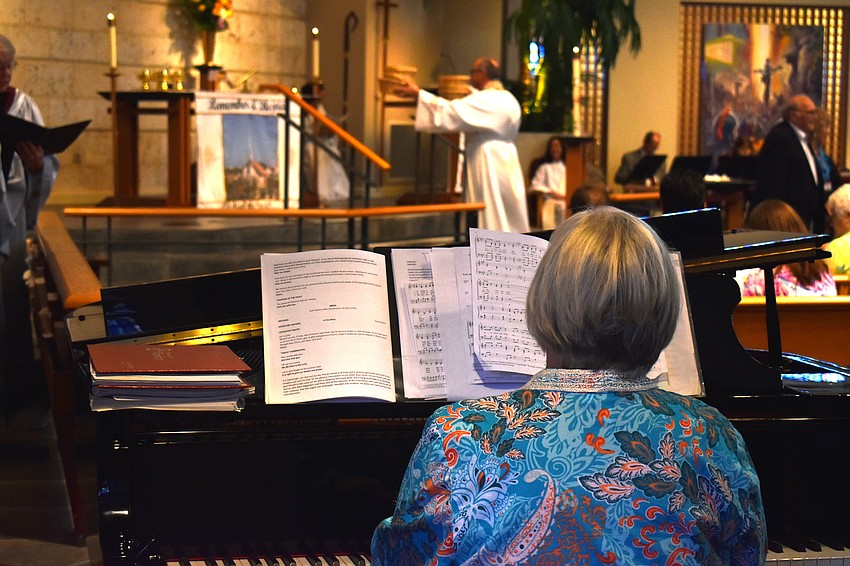 The choir sings as the Rev. Ken Blyth brings the gift toward the altar.