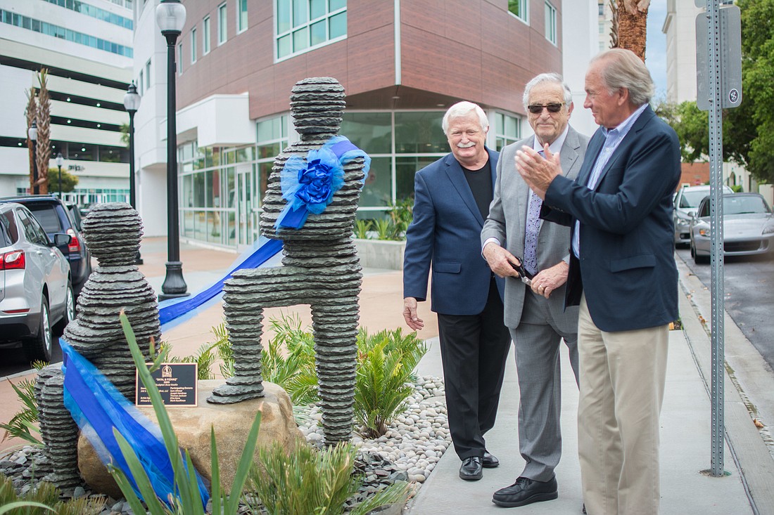 Jim Shirley, Dr. Mark Kauffman and Sam Alfstad cut the ribbon during the statue&#39;s dedication ceremony.