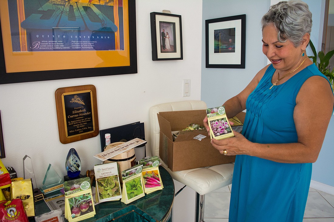 Elizabeth Cuevas-Neunder displays one of the many packets of seeds she is donating to Puerto Rico.