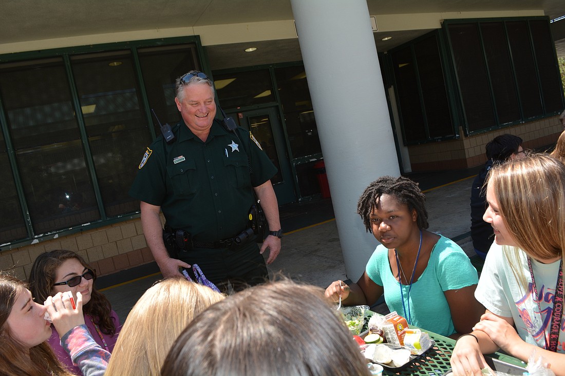School Resource Officer Dep. Carl McClellan chats with eighth-graders at Braden River Middle School during their lunch break.
